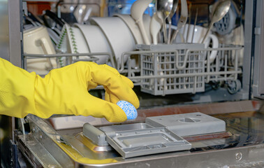 식기 세척기에 전용세제를 넣는 장면, 주방 위생 관리