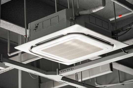 Ceiling-mounted square cassette air conditioning unit with metal grille and ventilation system