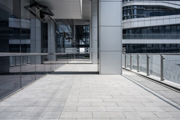 Obraz premium Modern architectural skybridge with glass curtain wall and empty stone-paved walkway