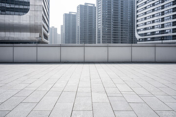 Fototapeta premium Urban plaza with empty stone pavement and towering modern skyscrapers in the background