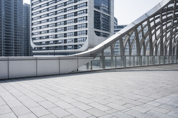 Modern urban pedestrian bridge alongside glass-clad high-rise buildings in a clean cityscape © zhu difeng