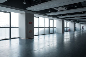 Fototapeta premium Spacious modern office space with large floor-to-ceiling windows and excellent natural lighting