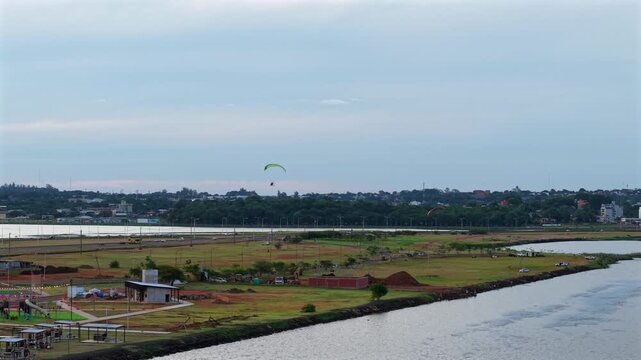 Wide shot of paramotors flying over the Paran&aacute; River near Balneario Costa Sur in Posadas, Misiones.