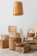 Fototapeta premium Interior of stylish living room with rattan chairs, lamp and different wicker baskets