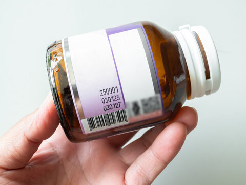 Expire drugs check, finger woman holding bottle mfg and exp date infomation, supplement food product, blur medicine label, blur text.