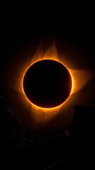 A darkened sun with a glowing orange ring