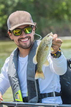 Smiling fisherman holding a smallmouth bass