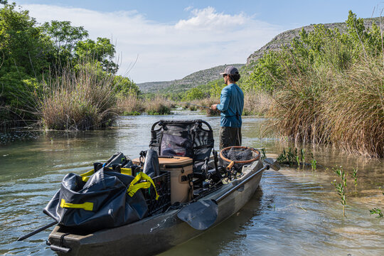 Angler Standing in Loaded Fishing Kayak on Scenic River