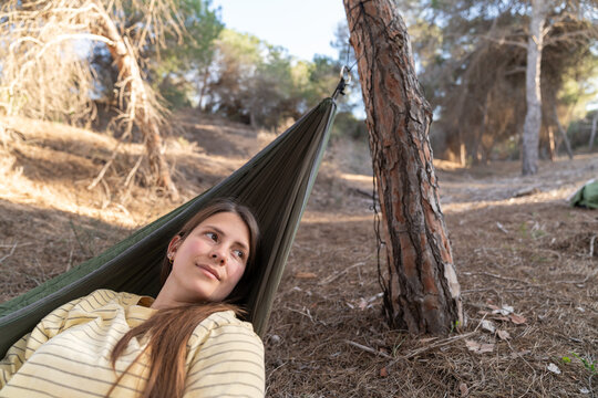 Woman relaxing in hammock enjoying nature in pine forest