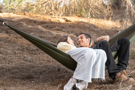 Couple relaxing together in hammock during nature getaway
