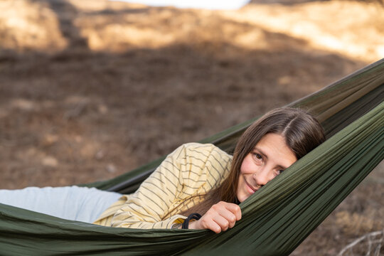 Woman relaxing in a green hammock outdoors enjoying leisure time
