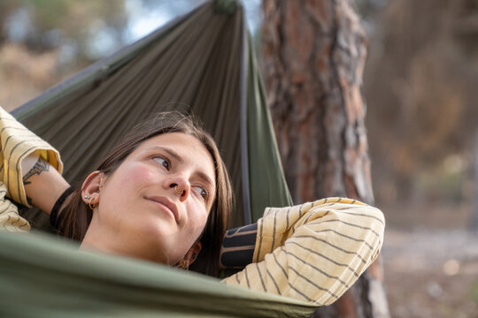 Young woman relaxing in hammock outdoors enjoying nature