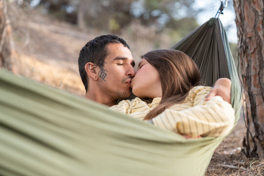 Couple kissing in hammock enjoying nature outdoors