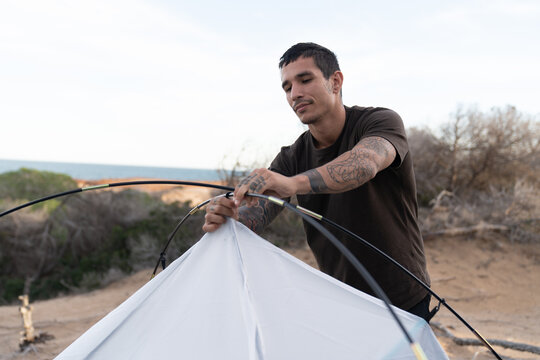 Man setting up tent for beach camping adventure