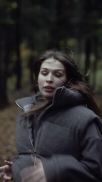 Frightened woman running through autumn forest