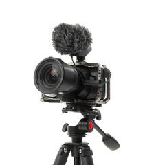 Modern photo camera with windscreen on tripod against white background