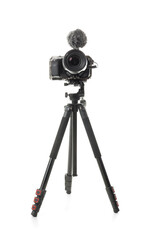 Modern photo camera with windscreen on tripod against white background