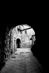 Naklejka premium Borghi toscani in bianco e nero. L'architettura medievale dei borghi toscani, caratterizzata da pietra, cotto, riflette il periodo comunale con cinte murarie, torri, vicoli stretti e piazze. Italia. 