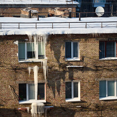 winter ice and icicles on old brick wall, urban decay scene