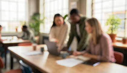 Three blurred individuals collaborate in a bright, modern workspace filled with plants, laptops, and documents. The setting is inviting and contemporary.