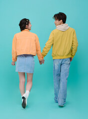 Young couple walking away holding hands in romantic lifestyle moment symbolizing lasting love commitment and future journey together in modern casual fashion.
