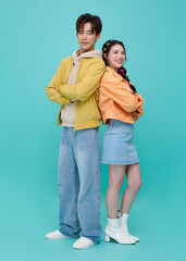 Friendship lifestyle concept with Asian young couple standing back to back smiling confidently expressing teamwork relationship bonding and modern casual fashion identity.