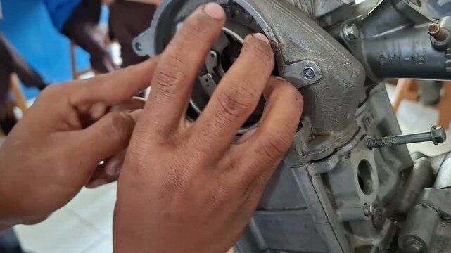 Close-up of vocational automotive student installing motorcycle timing chain during engine assembly practice in technical workshop