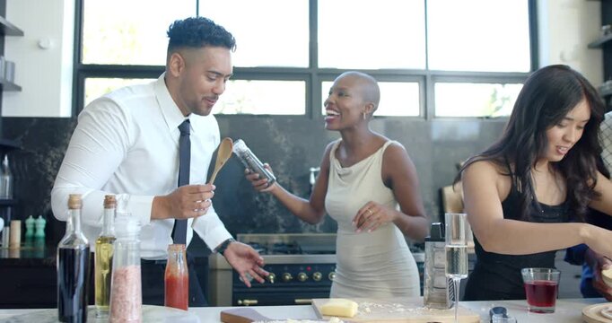 Diverse friends miming into wooden spoon, playful seasoning, assembling pizza to share meal