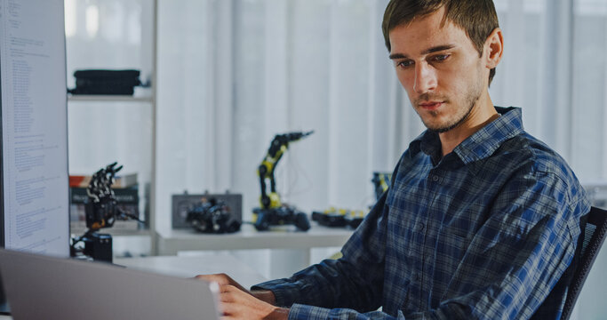Closeup young adult male freelance developer typing write prompt AI bot app program nomad terminal with coding at office. Artificial intelligence dashboard, robotics, user interface, machine learning.