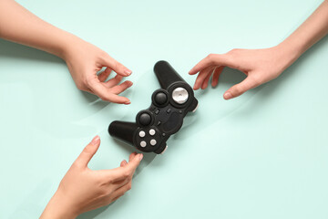 Female hands with modern game pad on color background © Pixel-Shot