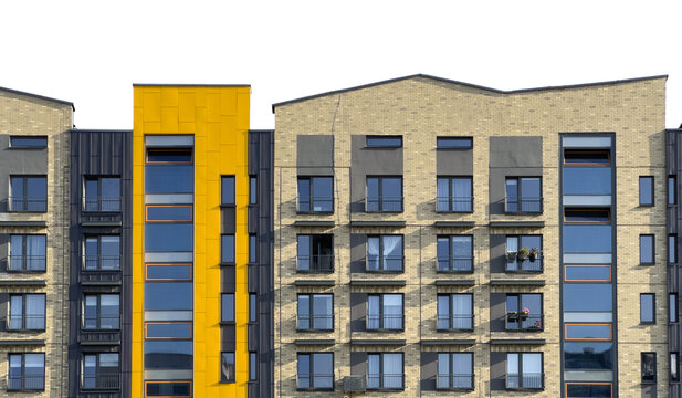 Modern apartment building facade in urban residential area. Brick exterior with yellow accent and