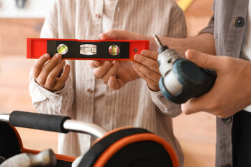 Father and his little son with different instruments assembling furniture in workshop, closeup