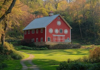 Obraz premium Serene red barn with white starburst decorations on stone foundation beside winding path in sunlit autumn meadow