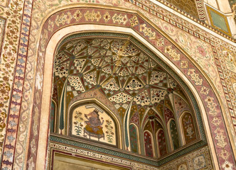 Obraz premium Jaipur palace arch displays colorful mural and intricate floral ornament across vaulted ceiling.