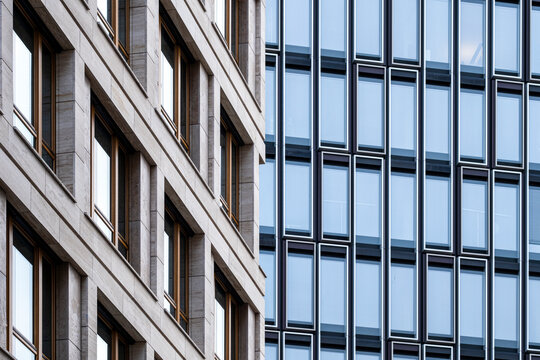 Corporate modern facade with stone and glass framing office windows in a repeating pattern highlighting urban architecture geometry and lines