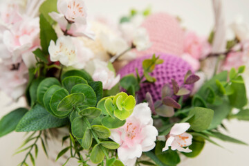 Spring equinox celebration. Easter theme composition with flowers and crocheted eggs. Featuring bouquets with handmade accents.