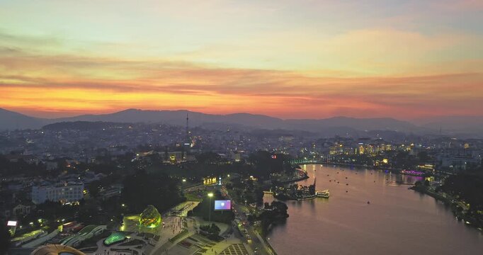 Aerial view of Da Lat city, Vietnam at sunset and night. Tourist city in developed Vietnam. Center Square of Da Lat city with Xuan Huong lake.