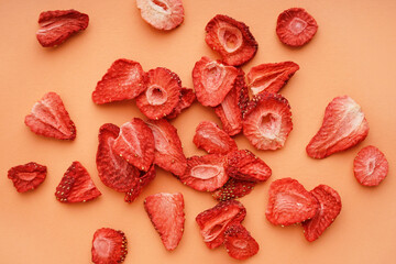 Tasty freeze-dried strawberries on orange background