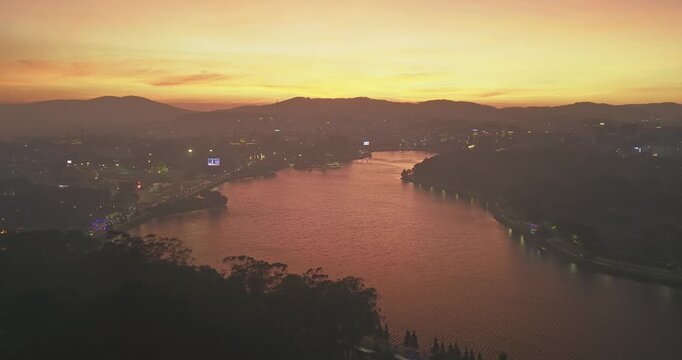Aerial view of Da Lat city, Vietnam at sunset and night. Tourist city in developed Vietnam. Center Square of Da Lat city with Xuan Huong lake.