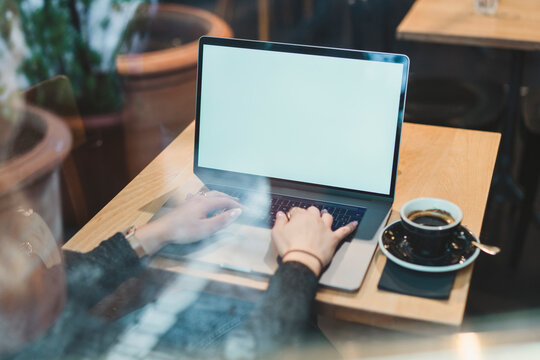 Close-up of woman using laptop on table in a cafe