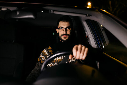 Portrait of confident man driving car at night