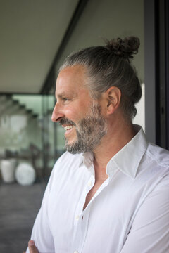 Portrait of happy mature man with hair bun