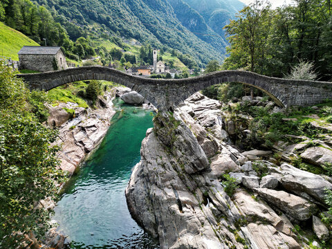 Mountain landscape with the famous, historic stone bridge Ponte dei Salti in the Verzasca Valley in the Swiss canton of Ticino in late summer