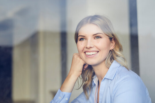 Portrait of content businesswoman looking out of window