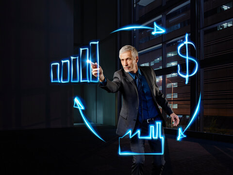 Businessman painting economic circulation with light