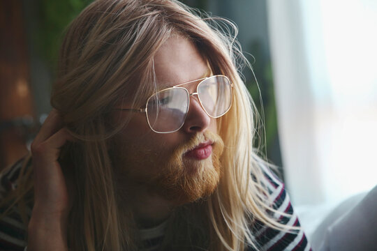 Portrait of man with long blond hair wearing spectacles