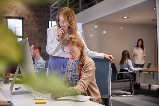 Young woman working in modern creative office, usine laptop
