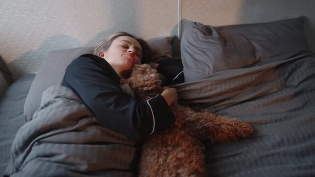 Young woman waking up in bed with her small dog in the morning. Cozy home atmosphere, soft light, calm start of the day. Concept of comfort, pet companionship, slow morning routine, emotional