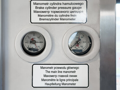 Two pressure gauges monitor brake cylinder and main line systems, indicating operational status and safety in industrial machinery or transportation