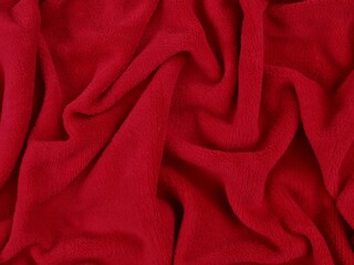Close-up of soft vibrant red fabric texture in swirl pattern. Ideal for background, textile industry concepts, or winter warmth themes © Eka